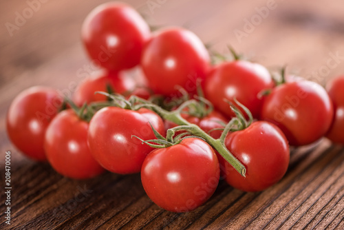 red ripe vine tomatoes on the vine on vintage old wooden background