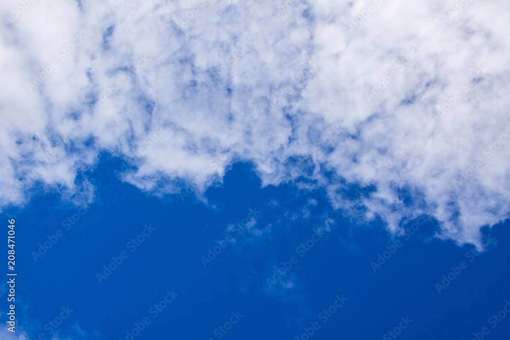 Fototapeta premium White clouds occupy half of the blue sky