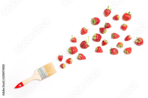 Fresh strawberries are scattered like a smear of paint from the brush - the concept of berry paint.