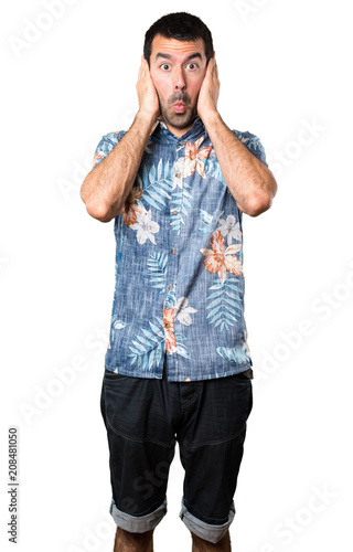 Handsome man with flower shirt covering his ears on isolated white background