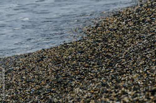 pebble beach washed by sea waves, small and various stones forming the shore