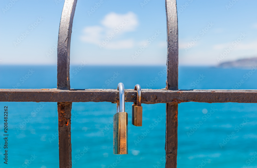 rusty padlock attached to a balustrade by the sea, a traditional way of showing love