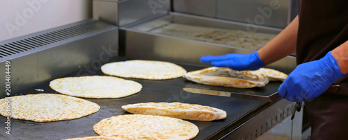cook with latex gloves cooking Italian food called piadina romagnola photo
