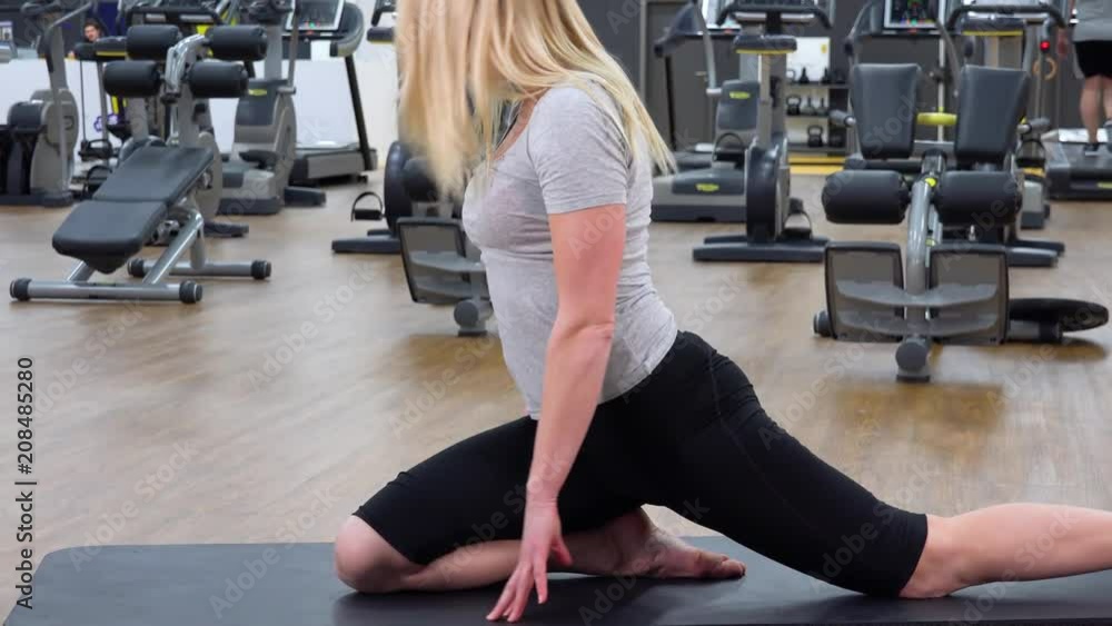 A young beautiful woman does yoga in a gym A young beautiful woman does yoga in a gym