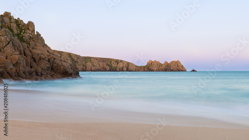 Stunning sunset landscape image of Porthcurno beach on South Cornwall coast in England