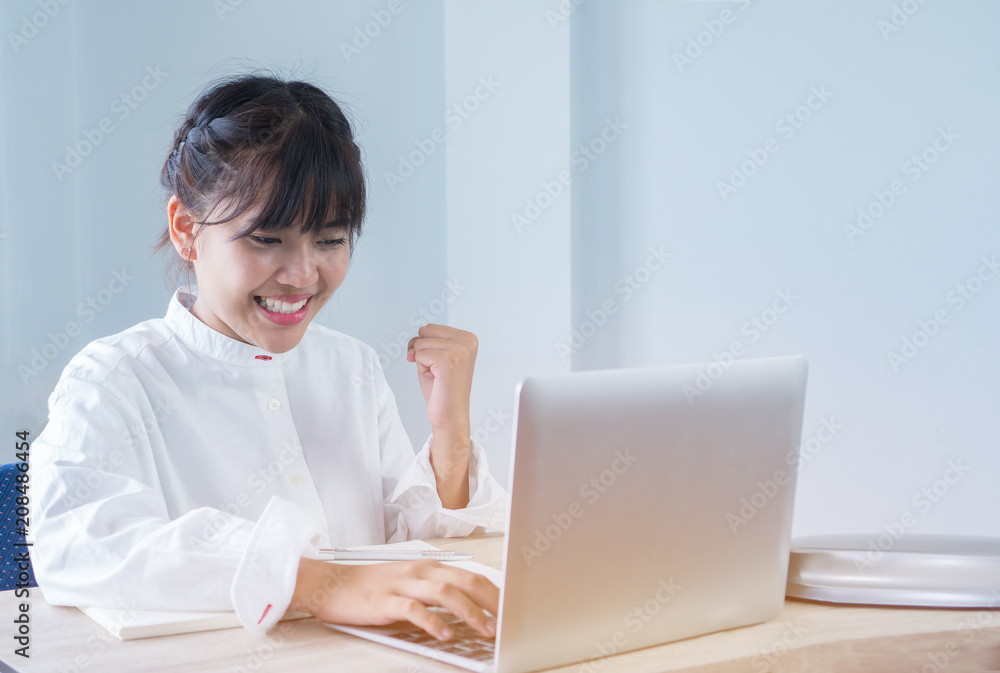 Asian Young Students or Start up Adolescents celebrate hands up after watching exam results in laptop, happy joy of accomplishing successful goal activities with expression positive emotion on campus