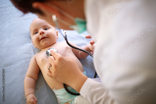Baby is checking up with stethoscope by pediatrician photo