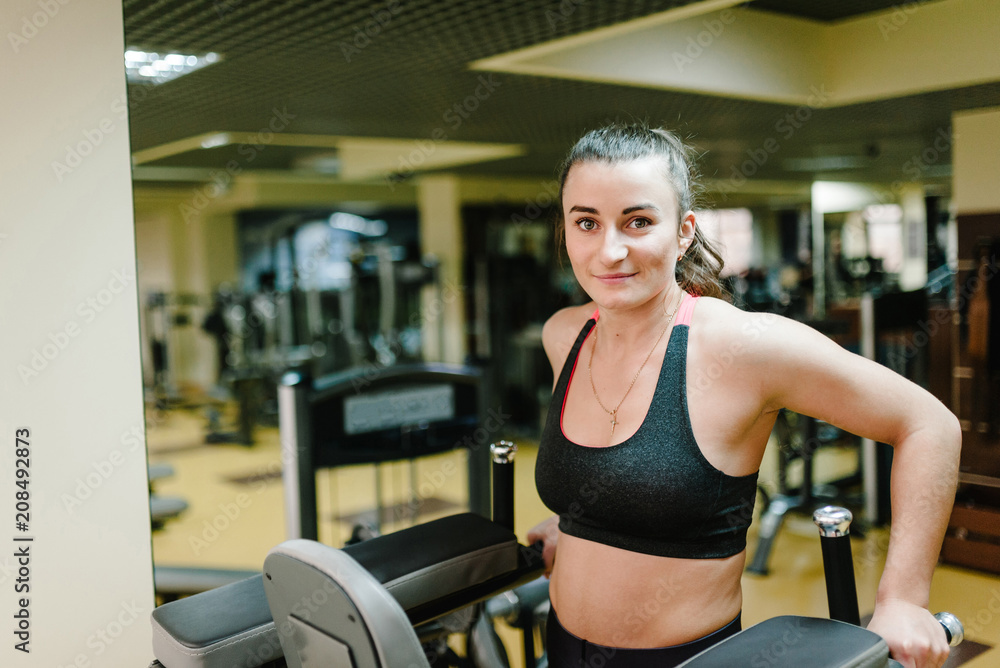 Portrait of sexy muscular girl wearing sportswear doing exercises on horizontal bar, exercises on the press in the gym club. Sport concept. Portrait of sexy muscular girl wearing sportswear doing exercises on horizontal bar, exercises on the press in the gym club. Sport concept.