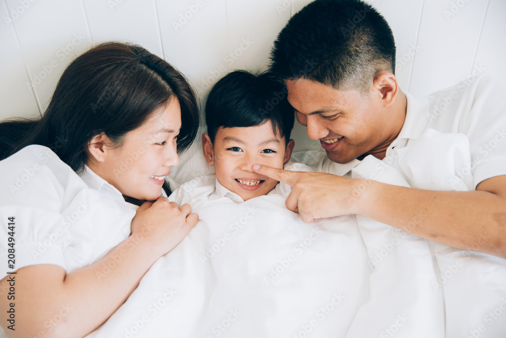 Fototapeta premium Happy aian family lying in bed and sleeping.
