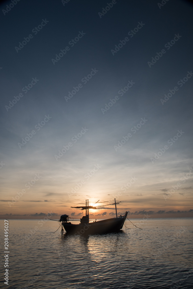 Fototapeta premium Fishing boat on the beach in the morning with sun rise.