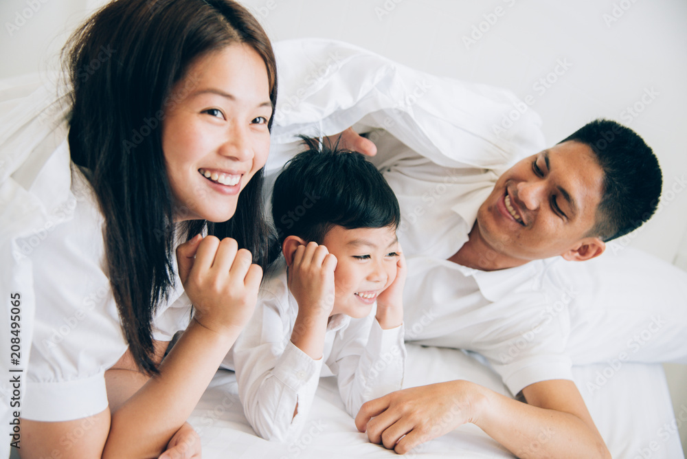 Happy aian family lying in bed and sleeping. Happy aian family lying in bed and sleeping.
