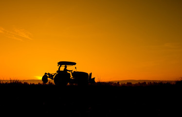Acrylglasbilder Traktor Silhouette eines Landwirts im Sonnenuntergang  © sunti