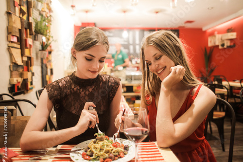 Pretty girls eating pasta