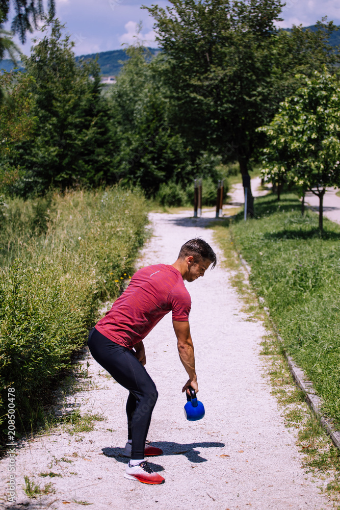 Young male model kettlebell exercise outdoor