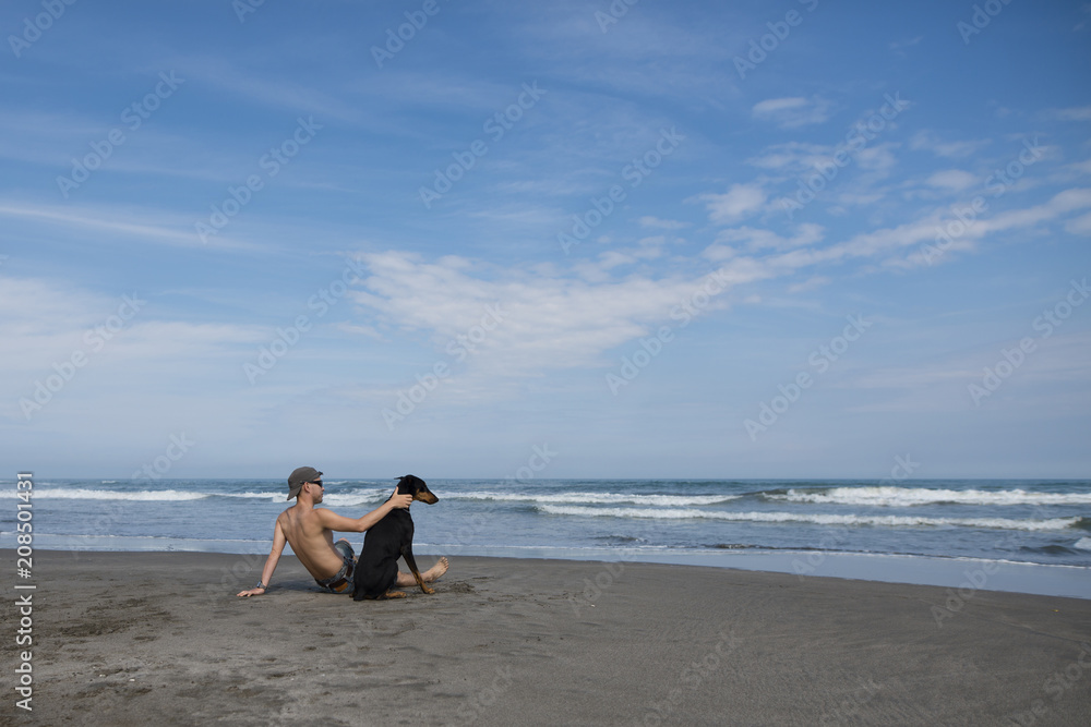 ビーチで愛犬と遊ぶ男性