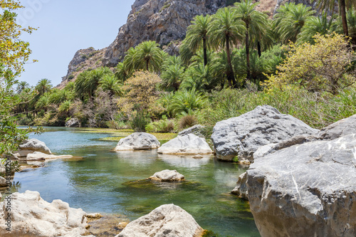 Wanderung durch die Preveli Schlucht auf Kreta Griechenland. Blick auf den Fluss mit Palmen, Wasser und Felsen