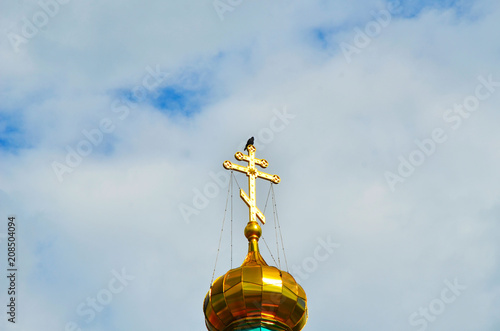 The dome of the Church with a cross against the blue sky