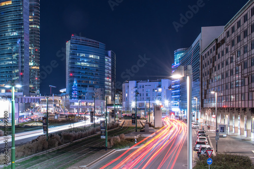 A cityscape of Gae Aulenti square in Milan at evening with car lights photo