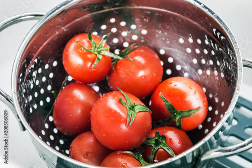 Tableau sur toile tomatoes fresh harvest washed in a colander in the kitchen