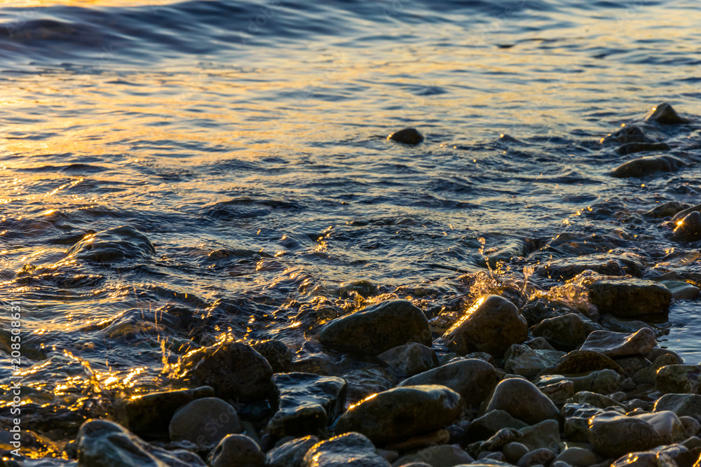 Gros plan de vague sur les rocher en coucher de soleil Gros plan de vague sur les rocher en coucher de soleil