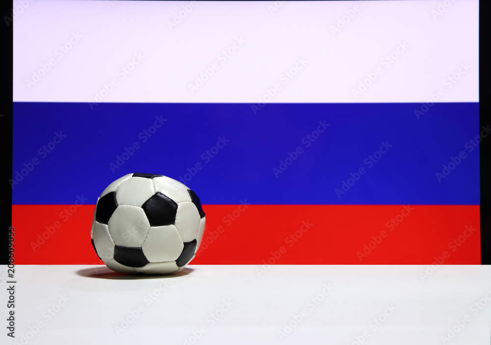 Small football on the white floor and Russian nation flag with white blue and red color background. The concept of sport. Small football on the white floor and Russian nation flag with white blue and red color background. The concept of sport.