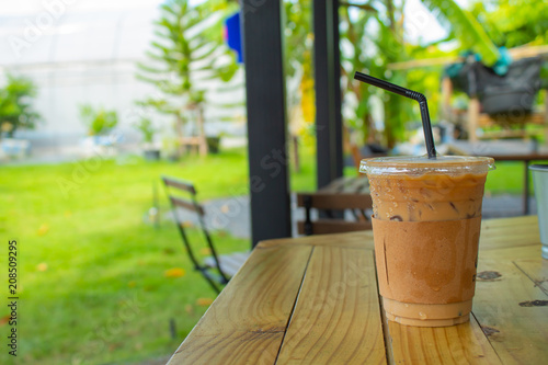 Iced coffee on a wooden table in the garden.
