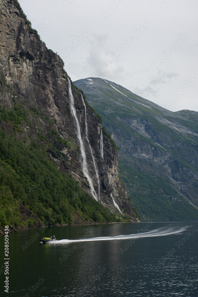 Boat in a Norweigan fjord with waterfalls