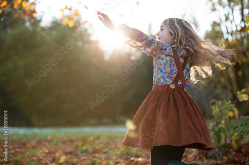 Girl Dancing in a Green Field at Sunset in the Fall
