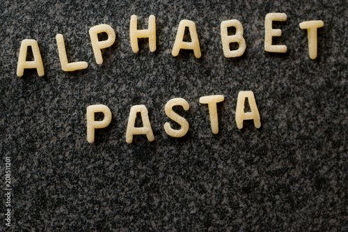 Raw Alphabet Pasta is Written with Letters on Granit Grey Surface.