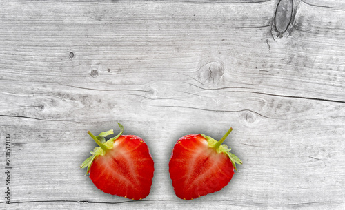 zwei halbe erdbeeren auf holz hintergrund