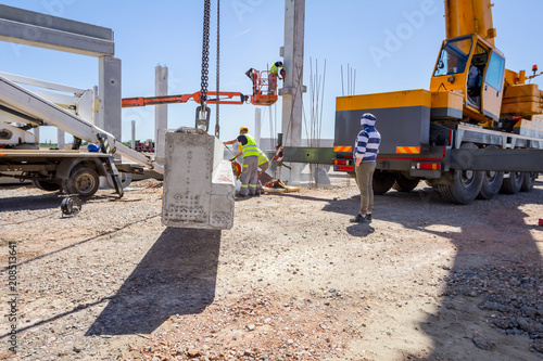 Photos Worker is using grinder for cutting cement pillar excess of material to correct