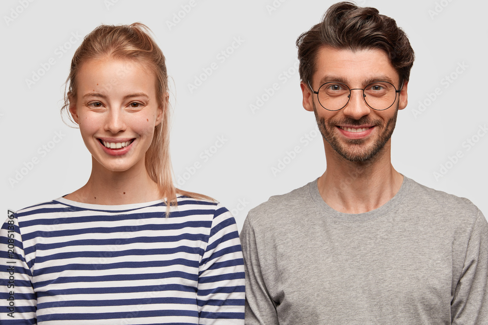 Lovely couple in love pose for making photo in family album, have charming smiles on faces, dressed in casual clothes. Happy European woman with pony tail rejoices making friends with handsome guy Lovely couple in love pose for making photo in family album, have charming smiles on faces, dressed in casual clothes. Happy European woman with pony tail rejoices making friends with handsome guy