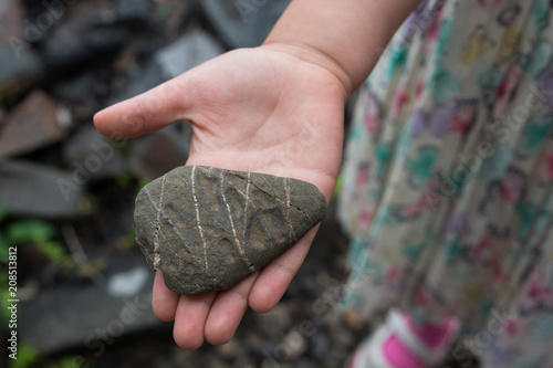 Closeup of a girl's hand holding a rock