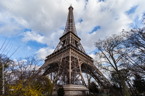 Wide angle view of iconic Eiffel tower with dramatic cloudy blue sky in the background. © Wojciech
