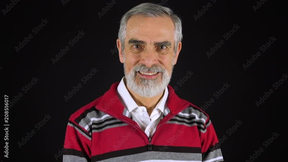An elderly man smiles at the camera - black screen studio An elderly man smiles at the camera - black screen studio