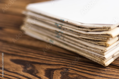 Heap of stacked newspapers on old brown wooden table
