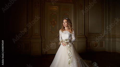 Beautiful bride with bouquet in luxury interior in the Baroque style.