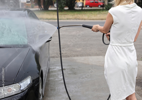 Woman washing car outside