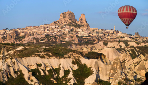 Balloon flying near the Uchisar Castle in Cappadocia, Turkey. Against the background of the blue sky.