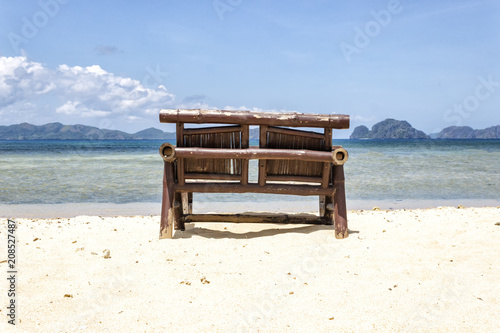 Chaise lounge on an exotic beach on a hot sunny day against the blue sea and sky.