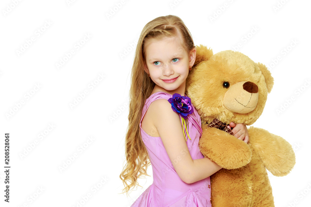 Beautiful little girl 5-6 years.She is holding a large teddy bea Beautiful little girl 5-6 years.She is holding a large teddy bea