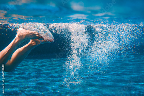 Men's legs swimming underwater in the swimming pool in summer © k8most