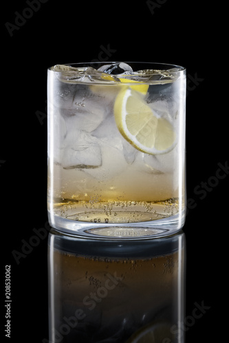 Apple bourbon and tonic in Rocks glass isolated on black