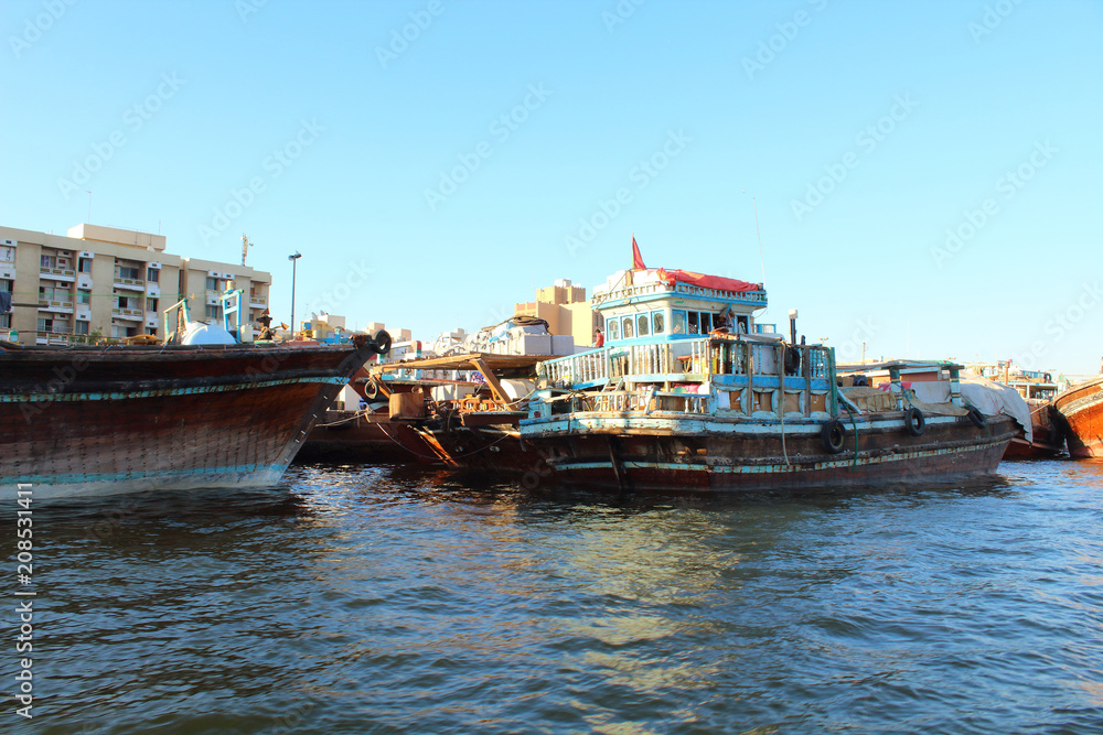 Trading wooden boats in the port. Merchant ships on the Creek Canal. Background. Landscape. Dubai Creek, March, 2018. Trading wooden boats in the port. Merchant ships on the Creek Canal. Background. Landscape. Dubai Creek, March, 2018.