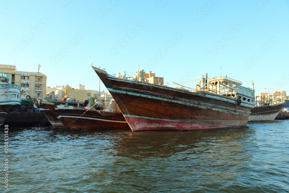 Obraz premium Trading wooden boats in the port. Merchant ships on the Creek Canal. Background. Landscape. Dubai Creek, March, 2018.