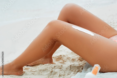 Summer holiday, applying sunscreen (suntan) creme