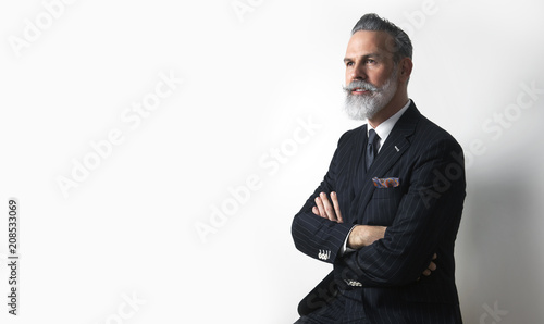 Fotografija Portrait of bearded attractive gentleman wearing trendy suit over empty white background