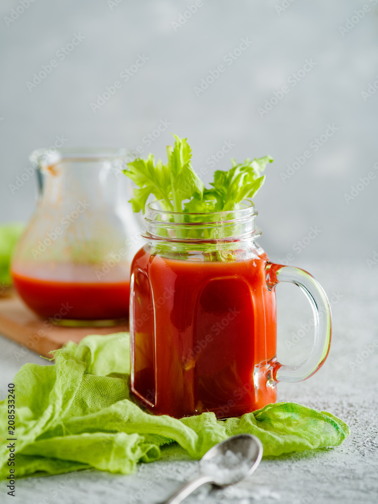 Tomato juice in mason jar with celery and salt. Tomato juice in mason jar with celery and salt.