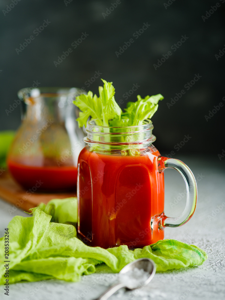 Tomato juice in mason jar with celery and salt. Tomato juice in mason jar with celery and salt.
