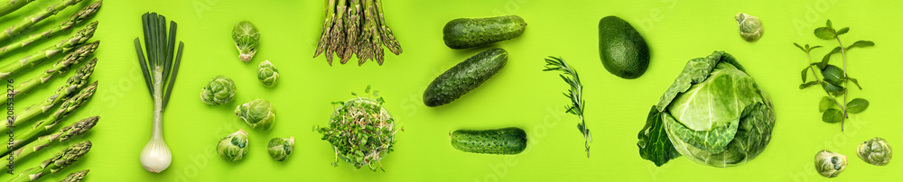 Green vegetables wide flat lay concept. Microgreens, brussels sprouts, asparagus, rosemary, avocado, onion, cabbage and cucumber on green background, top view - obrazy, fototapety, plakaty 
